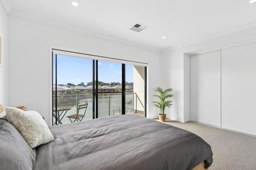 a bedroom with a bed and a large window at Waterside in Victor Harbor