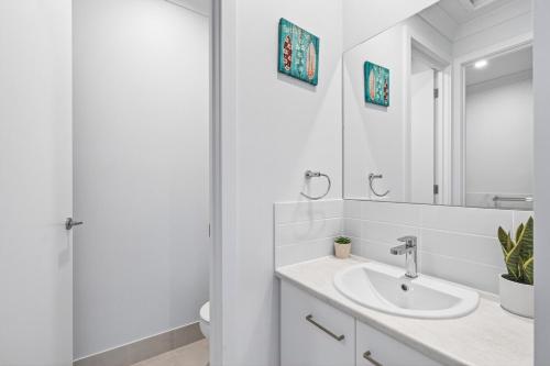 a white bathroom with a sink and a shower at Waterside in Victor Harbor