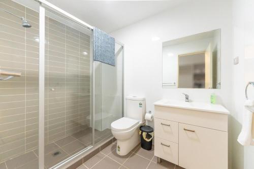 a bathroom with a shower and a toilet and a sink at Norwest business park in Baulkham Hills