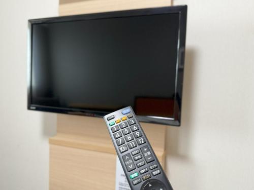 a remote control sitting in front of a television at Hotel La'gent Plaza Hakodate Hokuto in Hokuto