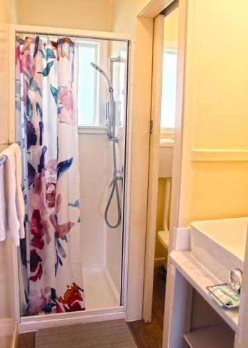 une douche avec une porte vitrée dans une salle de bain dans l'établissement Waitangi Beach Unit A, à Paihia