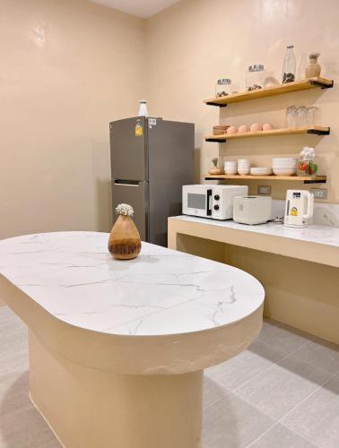a kitchen with a table and a refrigerator at Tamarind Pool Villa Kohlarn in Ko Larn