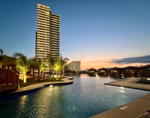 a large body of water with a tall building at Grand Sapphire 2 bedroom in Saint Yeorgios