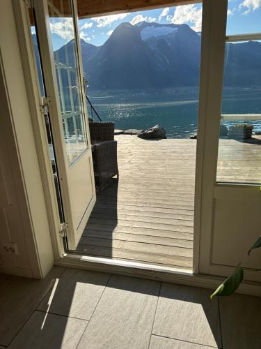an open door to a deck with a view of the mountains at Vollsnes Feriehus in Hjelle