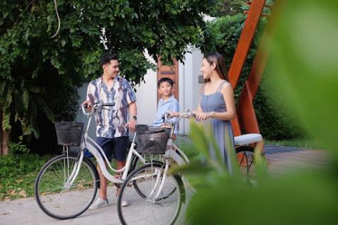 a man and a woman standing next to a bike at De Chaochom Hua Hin in Hua Hin