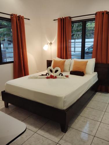 a bed with a flower on it in a bedroom at Roche Kerlan Apartments in Anse Kerlan