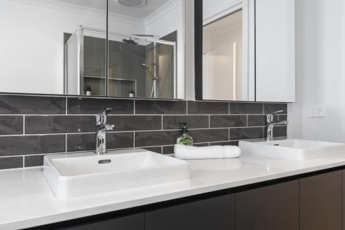 a bathroom with two sinks and a mirror at Family Home with Yard Near Armstrong Creek in Connewarre