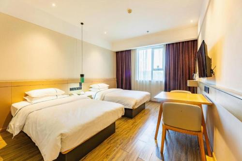 a hotel room with two beds and a desk at City Comfort Inn Wuhan Wansongyuan Wangjiadun East Metro in Wuhan