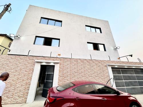 a red car parked in front of a building at Comfort zone in Futungo de Belas