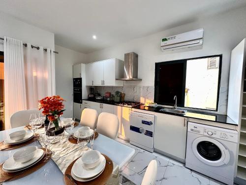 a kitchen with a table and chairs and a dining room at Comfort zone in Futungo de Belas