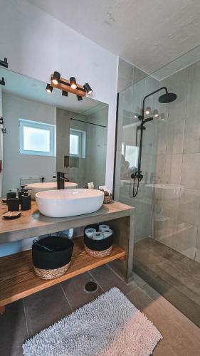 a bathroom with a tub and a shower with a mirror at Casa das Andorinhas-Alentejo in Vidigueira