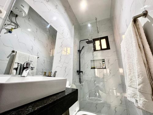 a white bathroom with a sink and a shower at Comfort zone in Futungo de Belas