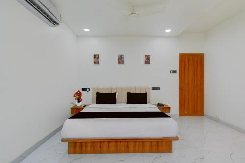 a bedroom with a large bed in a white room at Super Collection O Aurangabad Shendra MIDC Formerly Prayag Inn in Karmād