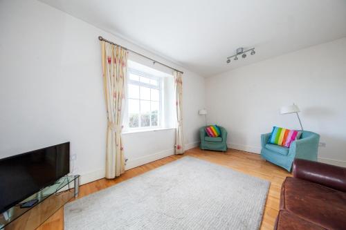 a living room with a couch and a window at Light Filled 2BD Home with Sea Views Baldoyle in Baldoyle