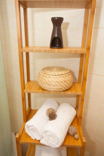 a wooden shelf with towels and a vase on it at Summer Lounge Apartments in Split