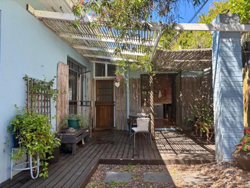 una terraza al aire libre con pérgola y mesa en Bottle brush Fishhoek, en Fish Hoek