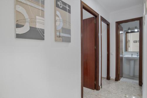 ein Flur mit einem Badezimmer mit Waschbecken und Spiegel in der Unterkunft Apartamento en Vejer in Vejer de la Frontera