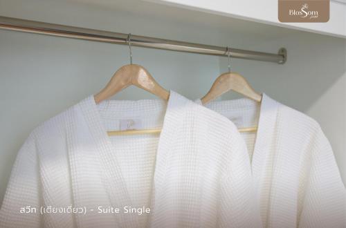 a white dress is hanging on a rod at โรงแรมบลอสซั่ม เพชรบูรณ์ Blossom Hotel in Phetchabun