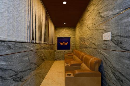 a waiting room with brown leather seats in a stone wall at S S B Grand in Ibrāhīmpatan