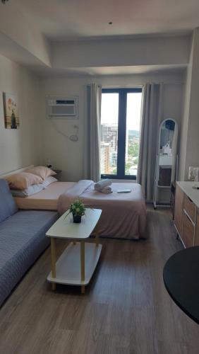 a living room with two beds and a couch at Studio Condo Fully Furnished-near IT Park in Cebu City