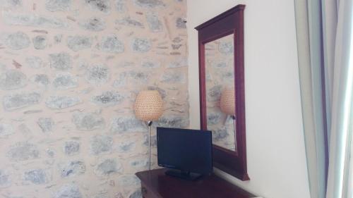 a television sitting next to a mirror in a room at Agriturismo Valle dell'Etna in Roccella Valdemone