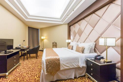 a hotel room with a bed and a desk and a computer at Wyndham Surabaya in Surabaya
