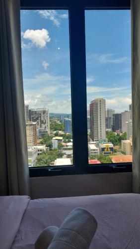 a bedroom with a view of a city from a window at Studio Condo Fully Furnished-near IT Park in Cebu City