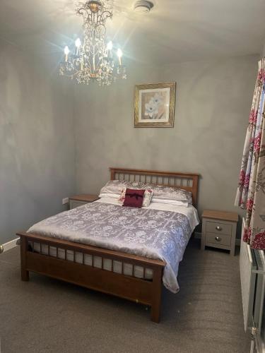 a bedroom with a bed and a chandelier at Country Cosy Cottage in Bailieborough