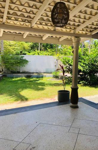 a porch with a potted plant in a yard at Coco Breeze Villa in Talpe