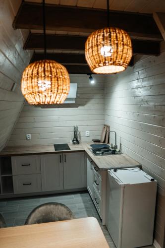a kitchen with two lights and a sink and a counter at В тиші Келечина in Kelechin