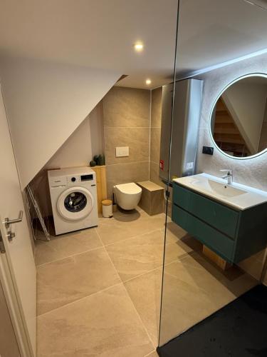 a bathroom with a sink and a washing machine at Duplex appartement en plein centre in Gérardmer