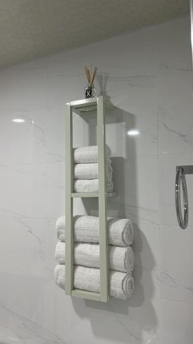 a stack of towels on a shelf in a bathroom at Alvina complex Vakas Tsakghadzor apartament in Tsaghkadzor