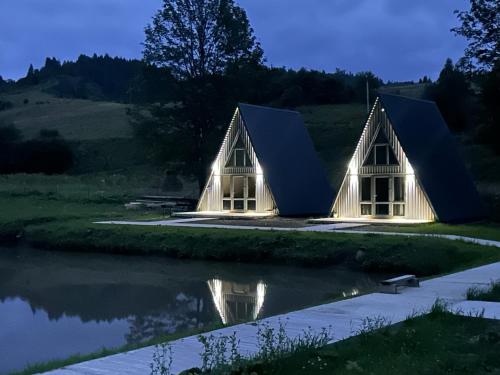 a house with a pitched roof and a pond at В тиші Келечина in Kelechin