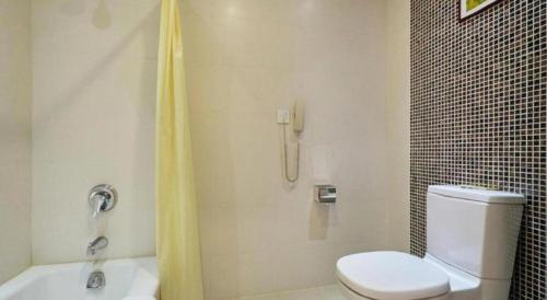 a bathroom with a shower with a toilet and a sink at Huangshan International Hotel in Huangshan