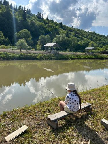 a child sitting on a bench fishing in a pond at В тиші Келечина in Kelechin