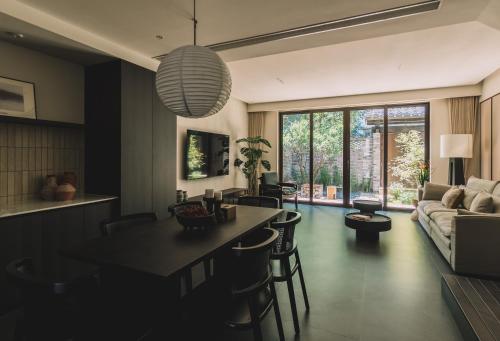 a kitchen and living room with a table and a couch at Huguang Hidden Villa Hotel in Chongqing