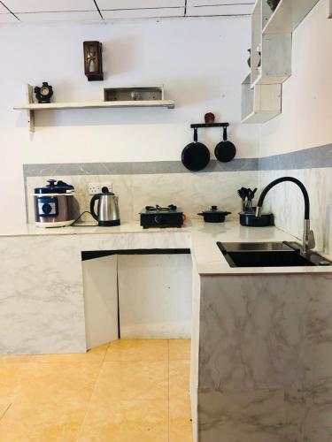 a kitchen with a sink and some pots and pans at Coco Breeze Villa in Talpe