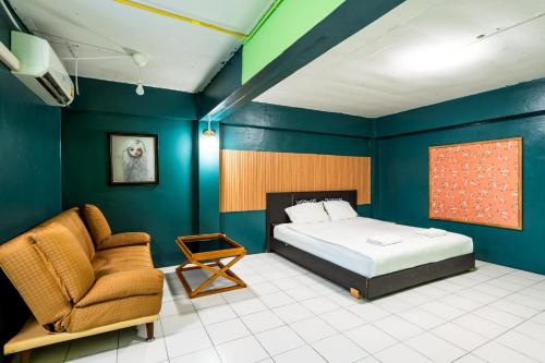 a bedroom with blue walls and a bed and a chair at xx GO INN The Grand Palace โกอินน์ MRT สามยอด in Bangkok