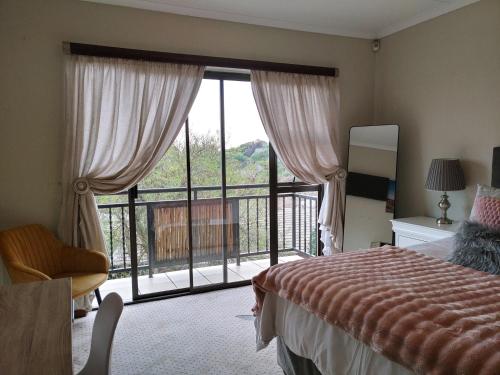 a bedroom with a bed and a large window at Sunrise Mountains View in Krugersdorp