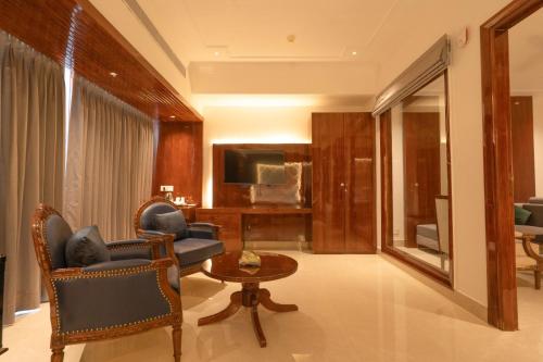 a living room with a couch and chairs and a television at GAJRAULA SUKHDEV DHABA and RESORT 