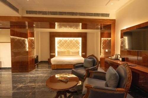 a hotel room with a bed and a table and chairs at GAJRAULA SUKHDEV DHABA and RESORT 