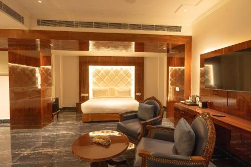 a hotel room with a bed and a television at GAJRAULA SUKHDEV DHABA and RESORT 