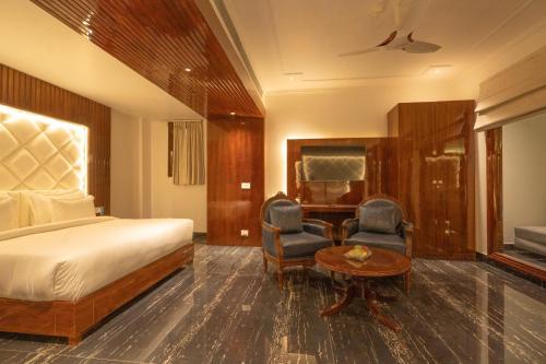 a hotel room with a bed and two chairs and a table at GAJRAULA SUKHDEV DHABA and RESORT 