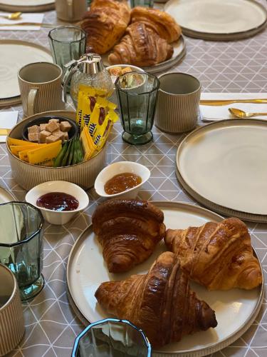 una mesa cubierta con platos de cruasanes y otros alimentos en La Fermette Champenoise, en Jonquery