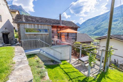 a house with a balcony and a house with mountains at Malvaglia in Malvaglia