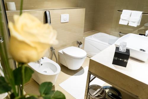 a bathroom with a white toilet and a sink at Ivory Inn Hotel Doha in Doha