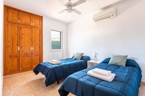 a bedroom with two beds and a ceiling fan at Villa Bini Mestral by Villa Plus in Binibeca