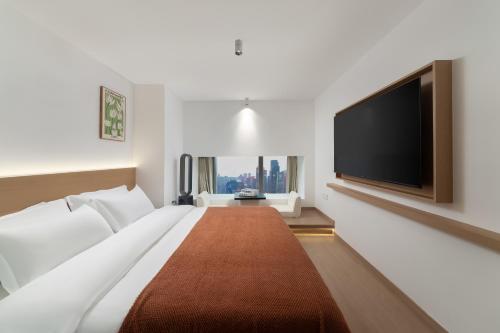 a hotel room with a large bed and a flat screen tv at Ouchen International Sky River Hotel (Monument to the people's Liberation Pedestrian Street Store, Chongqing) in Chongqing