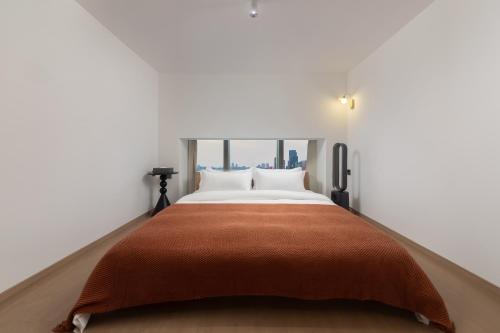 a bedroom with a bed with a orange blanket at Ouchen International Sky River Hotel (Monument to the people's Liberation Pedestrian Street Store, Chongqing) in Chongqing