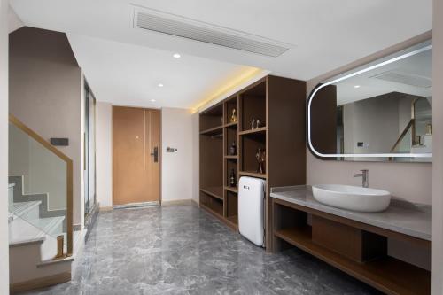 a bathroom with a sink and a mirror at Ouchen International Sky River Hotel (Monument to the people's Liberation Pedestrian Street Store, Chongqing) in Chongqing